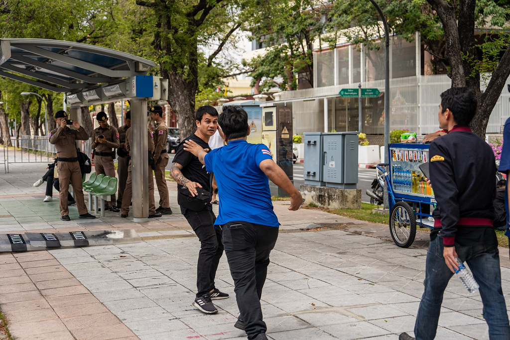 Songchai Niamhom, leader of an ultra-royalist group, trying to grab Weera Sangthong (black shirt), a leader of the Myanmar migrant worker network Bright Future before other ultra-royalist protesters attacked Weera at a demonstration in Bangkok on April 5, 2025. (Photo by Ginger Cat)