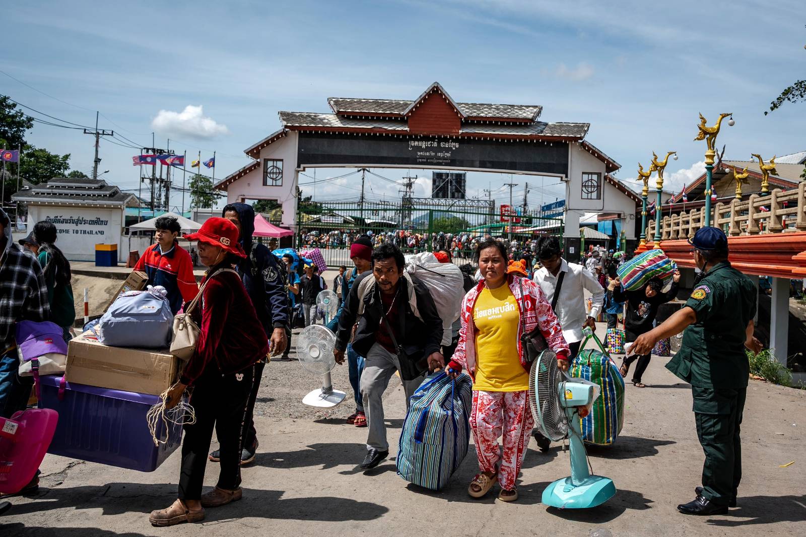 Cambodian workers carry their possessions in boxes and travel bags through the Ban Laem Border Gate in Cambodia's Battambang province on Aug. 3, 2025. (Roun Ry/Mekong Independent)