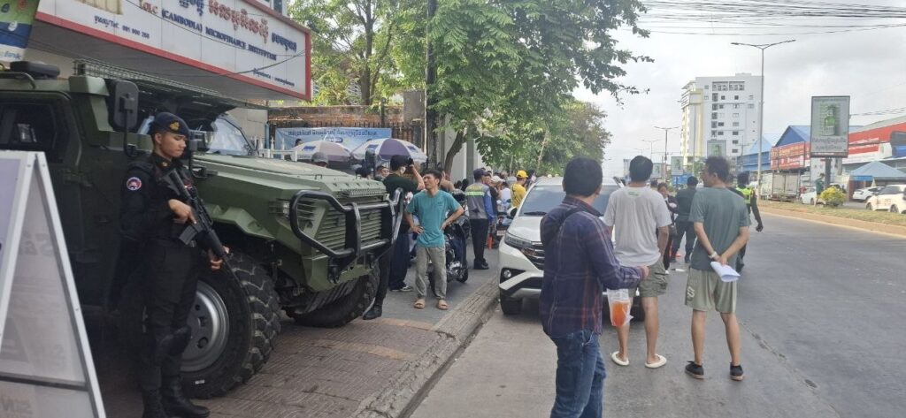 Authorities armed with assault rifles stand guard outside the gate of the National Bank of Cambodia during a protest of Huione Pay and HPay customers in Phnom Penh on April 24, 2026. (Danielle Keeton-Olsen/Mekong Independent/Creative Commons)