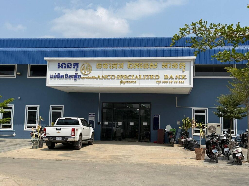 A truck and motorbikes park at the entrance of Anco Specialized Bank in Cambodia's Poipet city, which remained open after the U.S. treasury department announced sanctions against it, on April 30, 2026. (Mech Dara/Mekong Independent/Creative Commons)