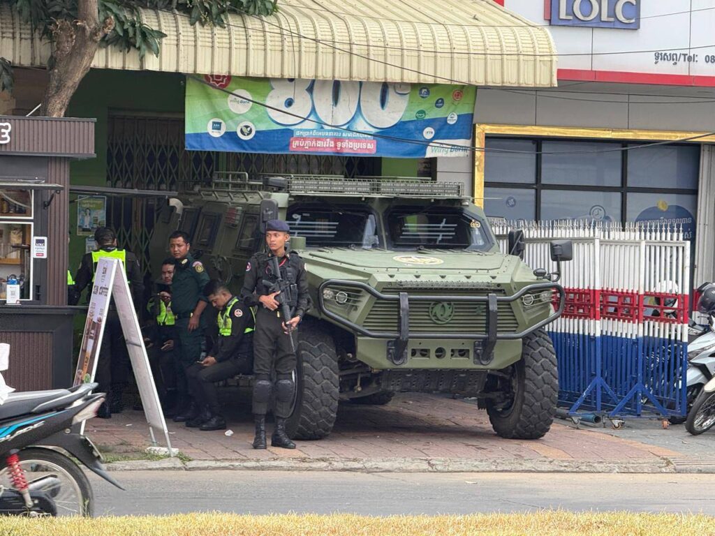 Law enforcement officials stand next to an armored truck close to the entrance of the National Bank of Cambodia during a protest of Huione Pay and H-Pay customers in Phnom Penh on April 27, 2026. (Mech Dara/Mekong Independent/Creative Commons) 