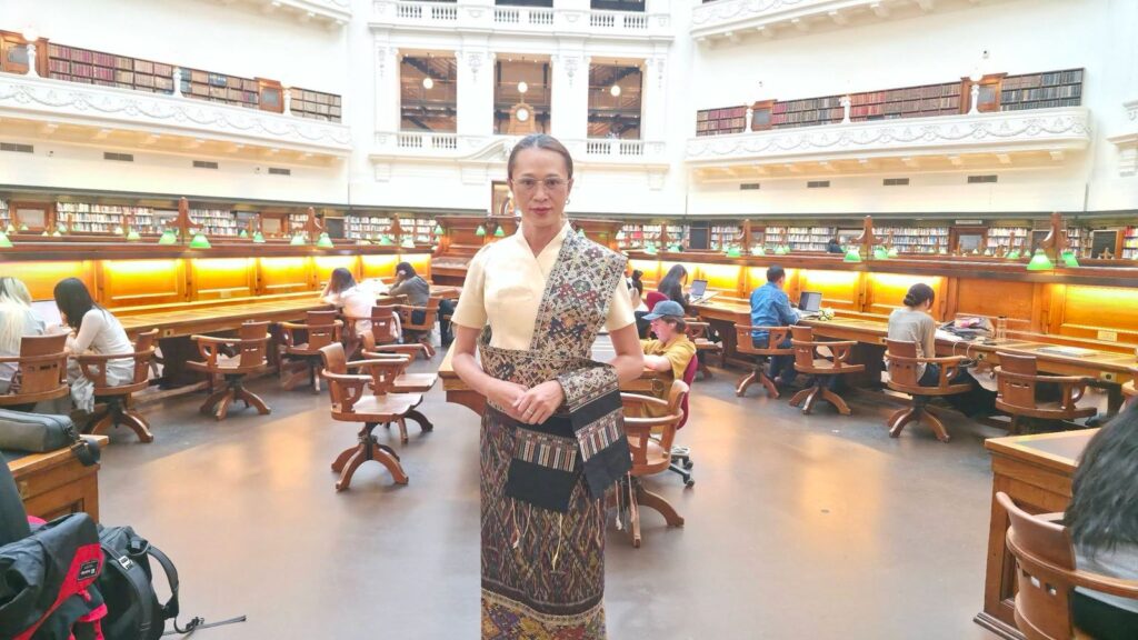 Thavadxai Xaiyakoumman, 36-year-old project officer of the LGBTQ+ organization Proud to Be Us Laos, stands in traditional Lao dress at the State Library Victoria in Melbourne, Australia. (Supplied)