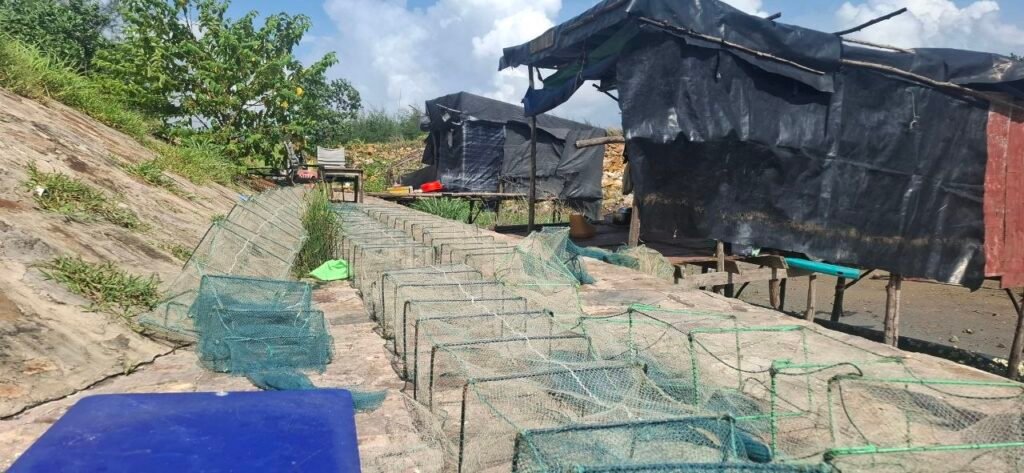 A makeshift hut for fishers and square fishing nets set up outside the Canopy Sands development zone, which fishers say was a rich fishing area before the development, on July 10, 2026. (Danielle Keeton-Olsen/Mekong Independent/Creative Commons)